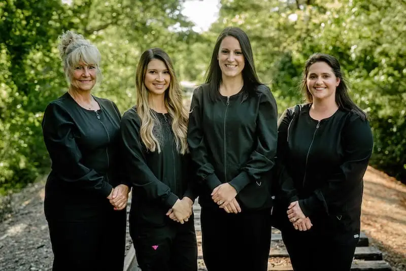 Four team members standing outside smiling.