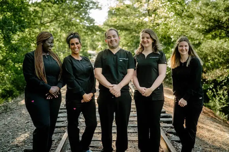 Five team members standing outside smiling.