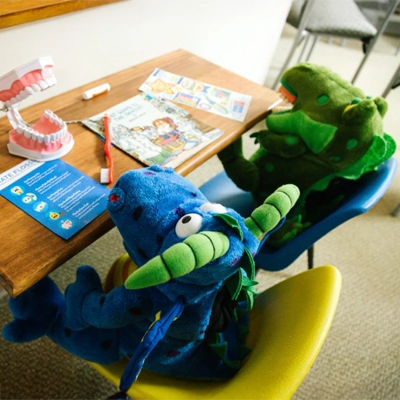 Two dragon stuffed animals sitting at a desk.