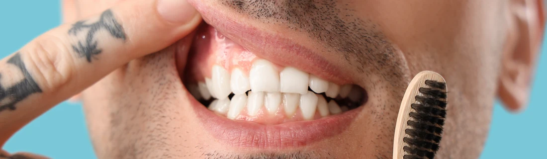 A man pointing at his mouth.